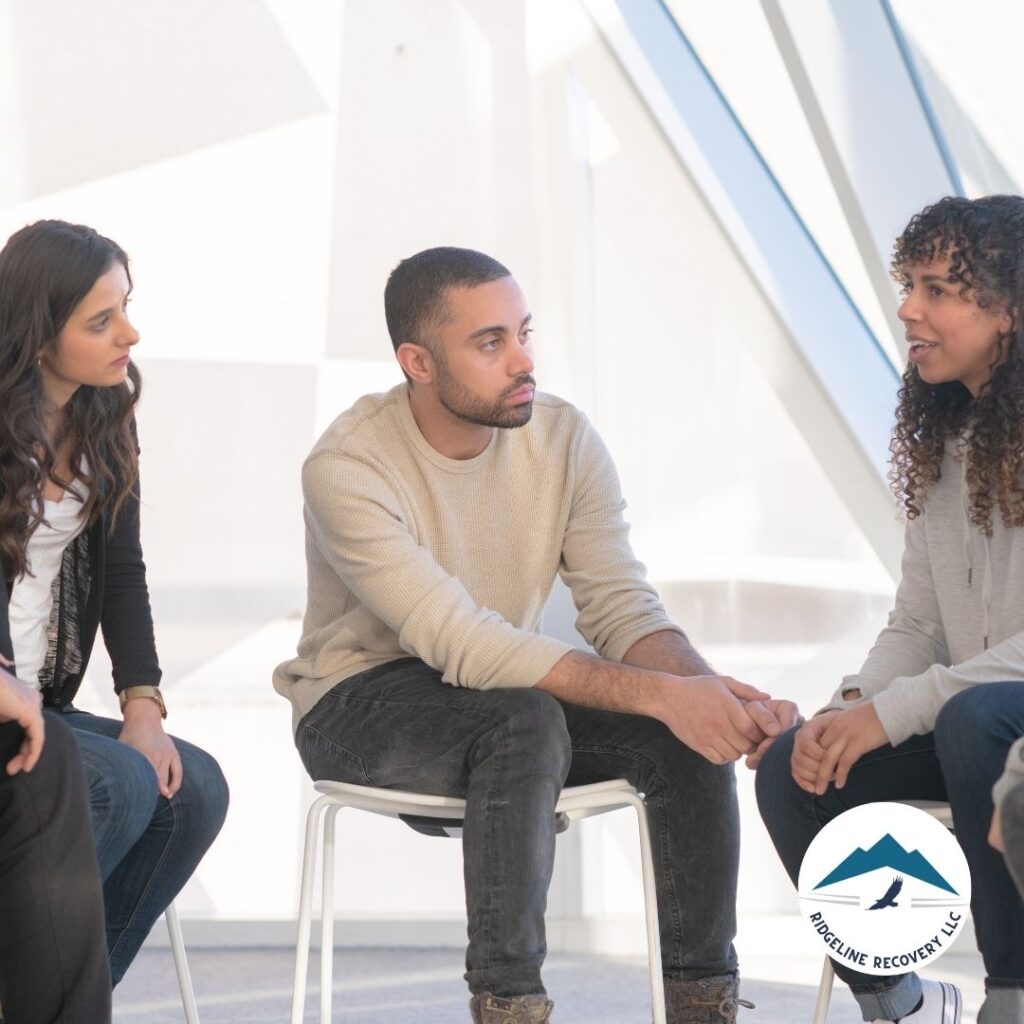 A therapist providing one-on-one addiction therapy to a client in a calming office environment.