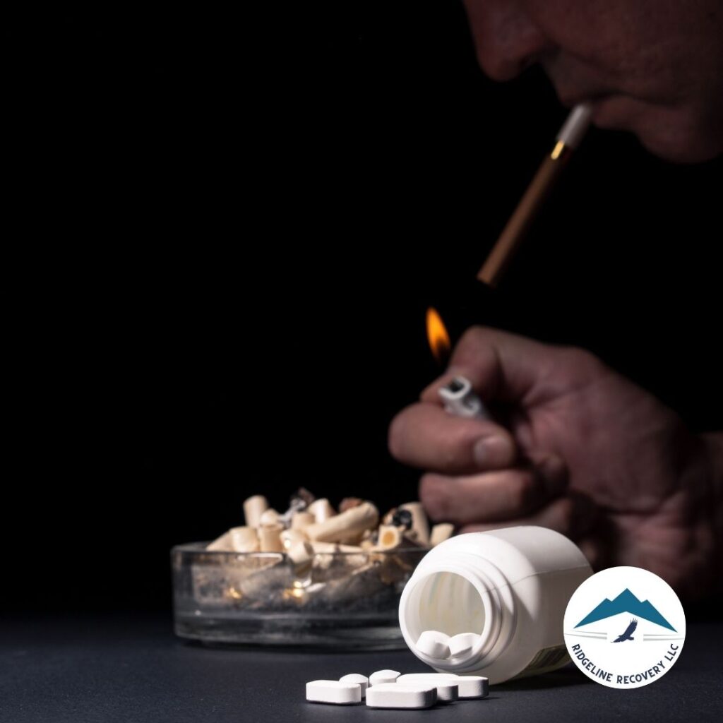 A person lighting a cigarette with a lighter, surrounded by pills and an ashtray, symbolizing addiction and the need for treatment.