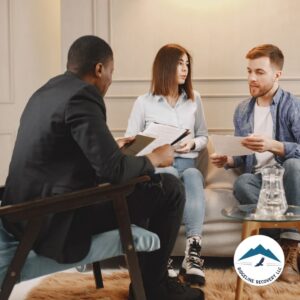 A group discussion in a professional setting, where individuals in Sober Living Columbus Ohio work together with a counselor to create structured recovery plans for a successful transition to independent living.