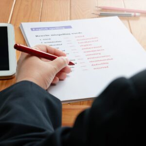 A person reviewing and correcting a worksheet, symbolizing how Addiction Worksheets help individuals reflect, learn, and improve during the recovery process.