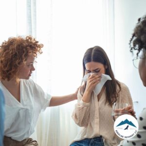 A woman receiving emotional support in a group therapy session, highlighting the compassionate care provided in a Long Term Inpatient Rehab Near Me program.