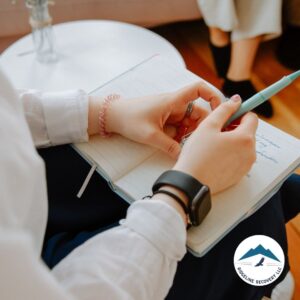 A close-up of a person journaling during a recovery session at Ridgeline Recovery, using Substance Abuse Handouts as a guide to self-reflection and healing.