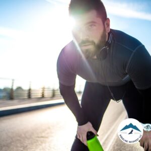 A determined man in athletic gear taking a break from running, symbolizing the journey of recovery. Searching for Rehab Centers Near Me That Accept Medicaid can provide the support needed for a fresh start.