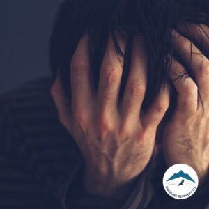 A distressed man with his hands covering his face, symbolizing the emotional burden of mental health struggles and the need for support from Mental Health Treatment Centers Near Me.