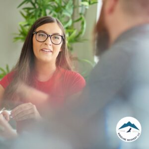 A young woman in a red shirt engages in a supportive discussion as part of Day Treatment Programs, focusing on addiction recovery and mental health support in Columbus, Ohio.