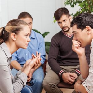 A close-up of a support group discussion, where individuals engage in a meaningful conversation using substance abuse group worksheets to aid their recovery journey.