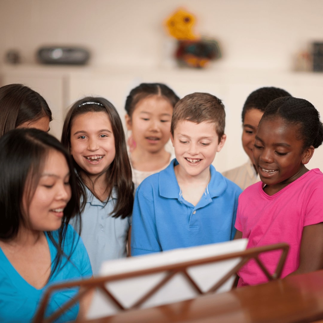 A group of children participating in a music-based activity as part of therapeutic behavioral services and day treatment programs, promoting emotional well-being and social development.