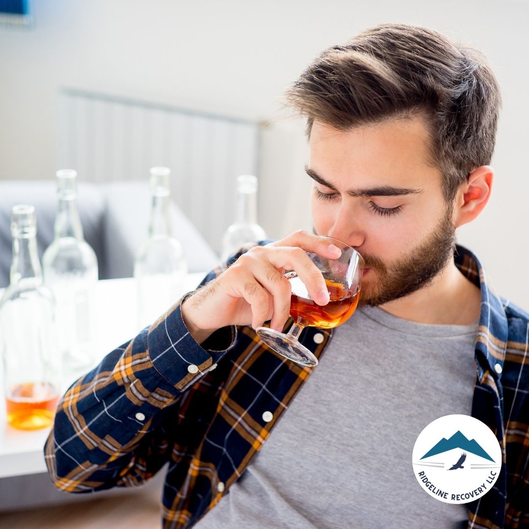 A close-up of a person holding a bottle of alcohol, symbolizing the complexities of alcohol addiction during addiction recovery in Columbus.