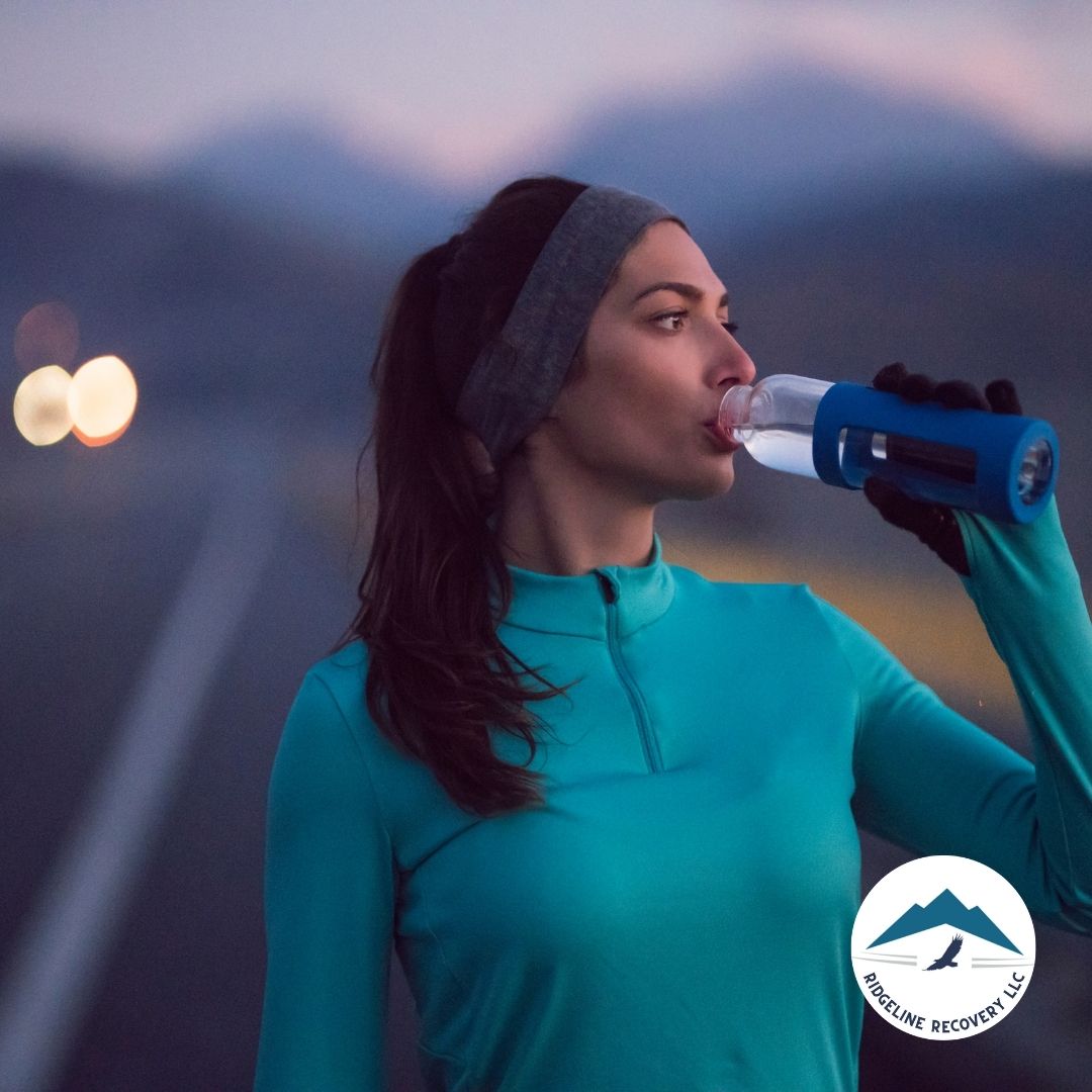 A woman in athletic gear drinks water after a run, symbolizing the commitment to a healthy lifestyle in sober living Columbus Ohio, where structured support helps individuals maintain sobriety.