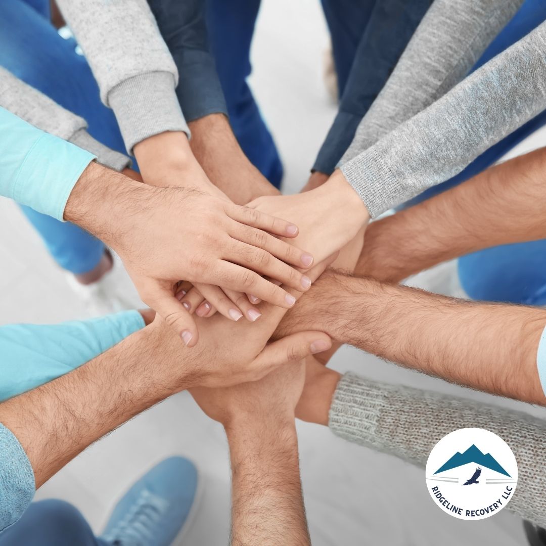 A close-up of diverse hands stacked together in unity, symbolizing the strength of community in addiction recovery. This reflects the core principles of the Refuge Recovery Book, emphasizing mindfulness, connection, and healing.