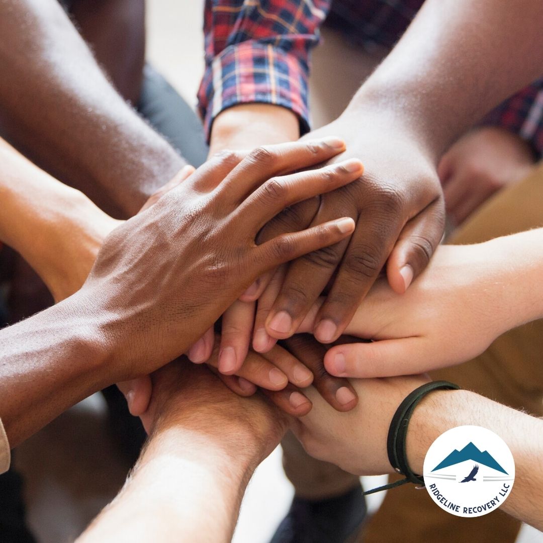 A diverse group of individuals joining hands in unity, symbolizing strength, support, and commitment to the Twelve Steps of NA in their recovery journey.
