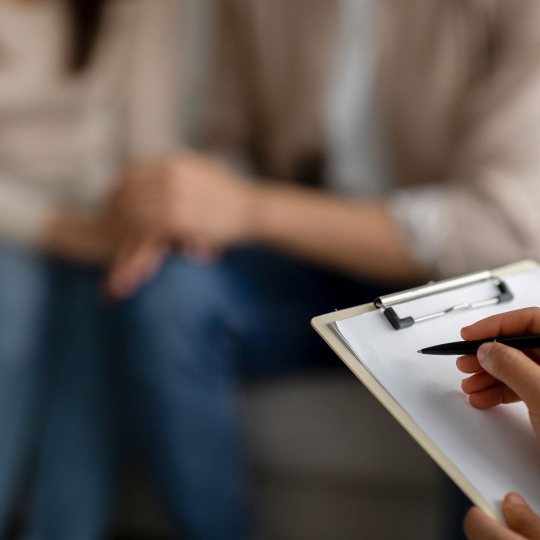A therapist taking notes while a couple sits closely together, symbolizing the journey of Rehab for Couples Ohio, where partners support each other through addiction recovery.