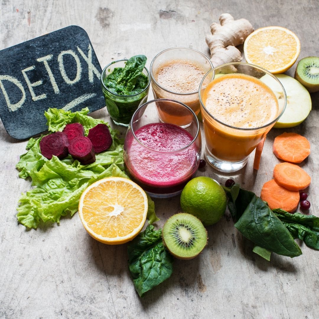 A variety of fresh detox juices, leafy greens, citrus fruits, and vegetables displayed on a wooden surface, symbolizing the role of nutrition in ambulatory detox for addiction recovery in Ohio.