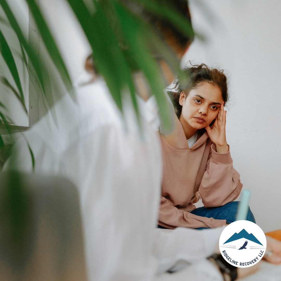 A young woman in a counseling session, reflecting on her recovery journey while using Free Addiction Worksheets as a tool for personal growth.