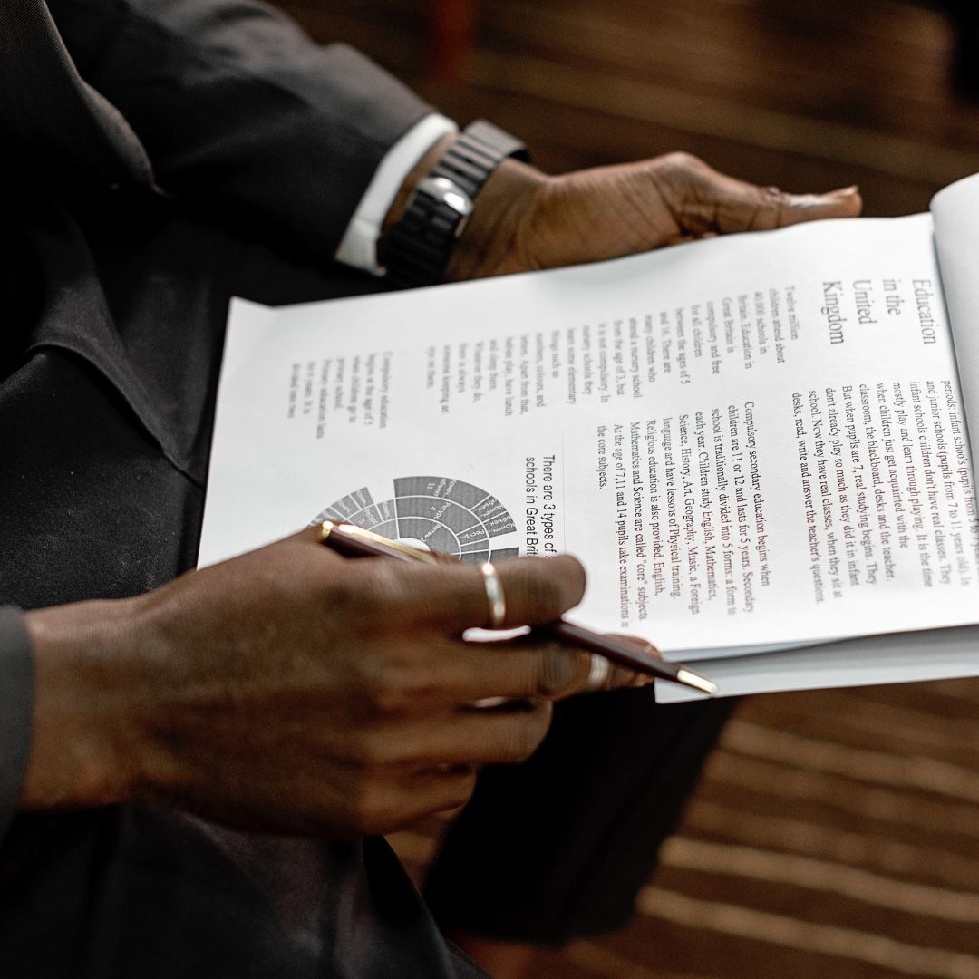 A person in professional attire holding and reviewing an educational document with a chart, symbolizing the importance of Free Addiction Worksheets in guiding individuals through structured recovery.