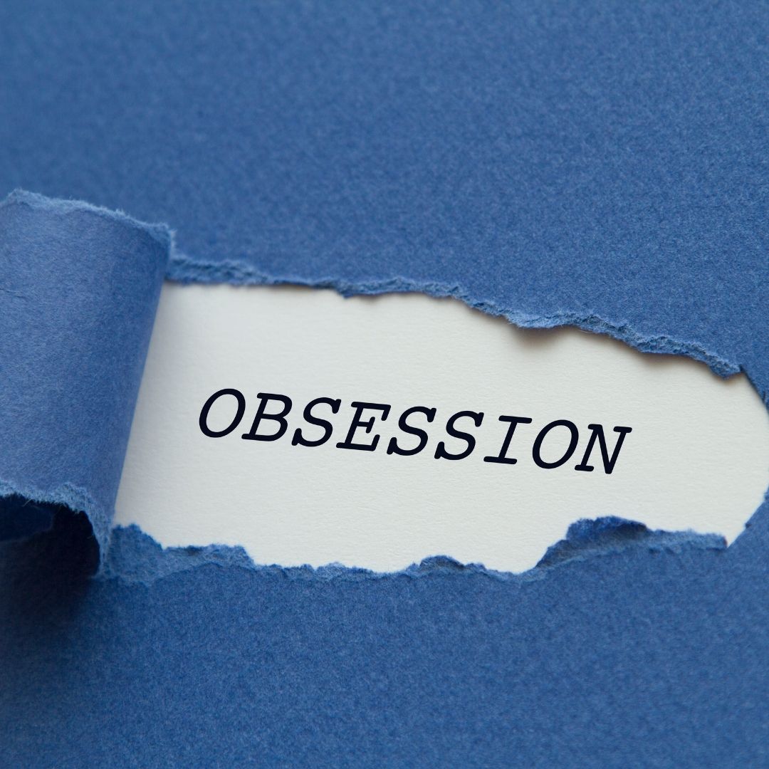 A torn blue paper reveals the word "OBSESSION," symbolizing the hidden struggles of the triangle of self obsession in addiction and mental health challenges.