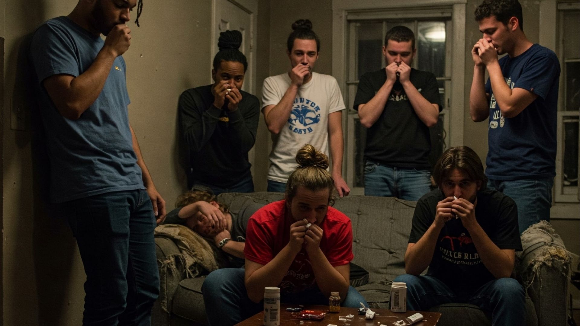 Do People Snort Adderall: A group of young adults exhibiting behaviors that could be associated with snorting a substance, with pill bottles on a nearby table.
