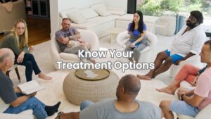 A group of people seated in a therapy circle participating in addiction treatment counseling.