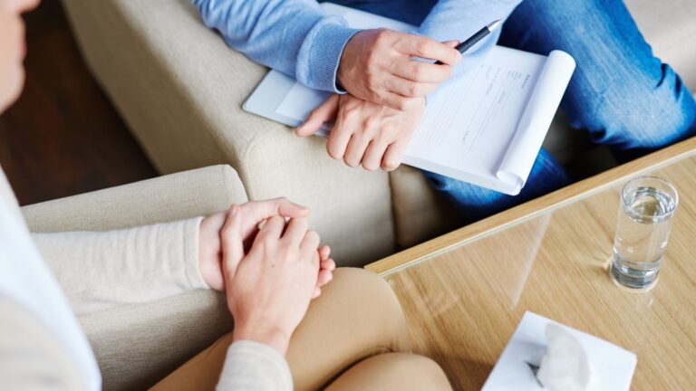 A counselor providing aftercare support to a patient during a private consultation.