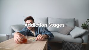 Man drinking alcohol and consuming drugs alone in dim light, showing signs of needing drug and alcohol rehab.
