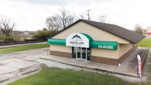 Exterior view of the Ridgeline Recovery center building in Columbus, Ohio, with a green awning and the phone number 614-618-5000 clearly visible.