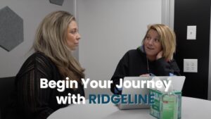 A professional image depicting a supportive, one-on-one consultation or intake session between a clinician and a client. The focus is on the human element of starting treatment. The text overlay, "Begin Your Journey with RIDGELINE", encourages the first step, linking the individual choice to the question of how effective is rehab will be with professional guidance and support.